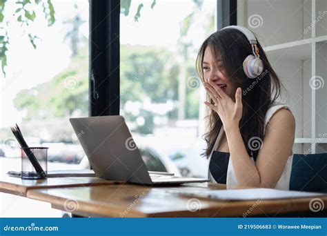 Joyful Businesswoman Sitting At Desk Looking At Laptop Screen Talking