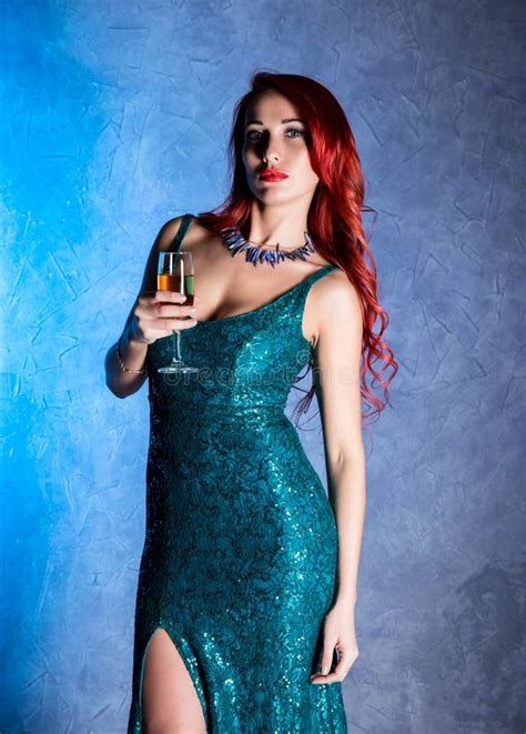 giovane donna sexy con le grandi tette in bicchiere di vino blu della tenuta del vestito