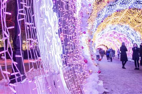 people and tourists walk along tverskaya street decorated for new year and christmas holidays