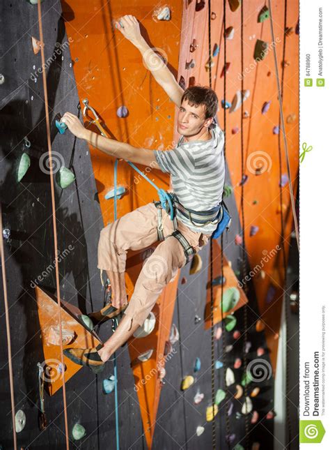 Male Rock Climber Practicing Climbing On Rock Wall Indoors Stock Photo
