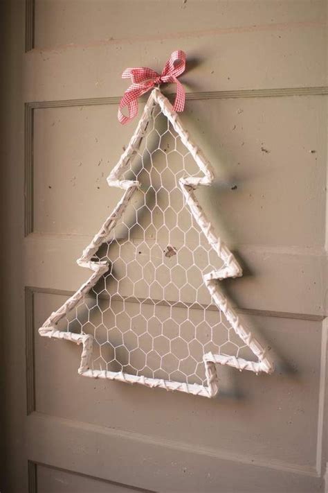 A Chicken Wire Christmas Tree Hanging On The Side Of A Door With A Pink Bow