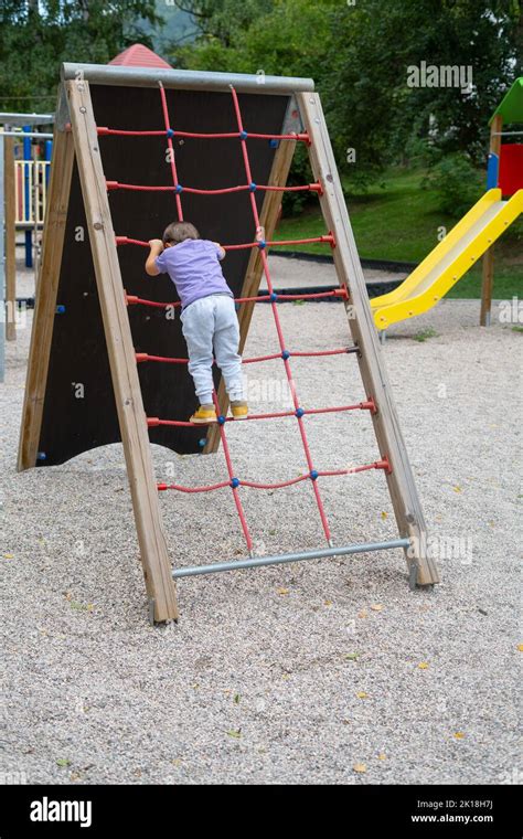A Boy Not Recognizable Climbs A Rope Ladder In A Childrens Park