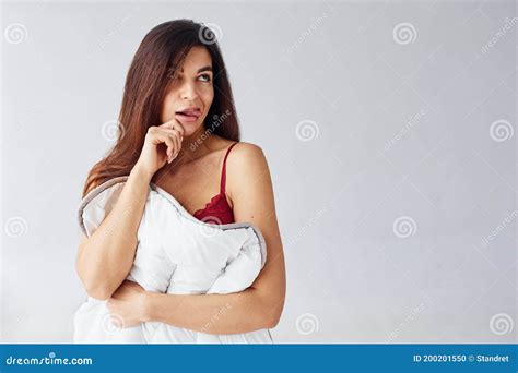 Woman In Red Underwear Covering Her Body By Towel In The Studio Against White Background Stock