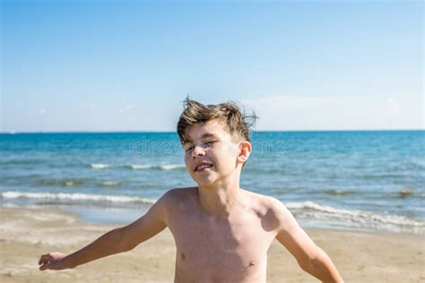13 Jahre Alte Junge Wirft Oben Seine Hände Und Das Schreien In Den Meereswellen Konzept