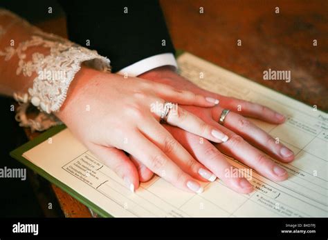Newly Wed Married Husband And Wife Holding Hands On Wedding Register