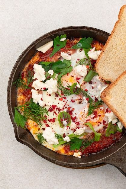 Una sartén de plato del medio oriente shakshuka con tostadas Foto Premium