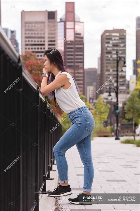 Side View Of Woman Leaning On Railing On A Sunny Day Modern Pretty Stock Photo