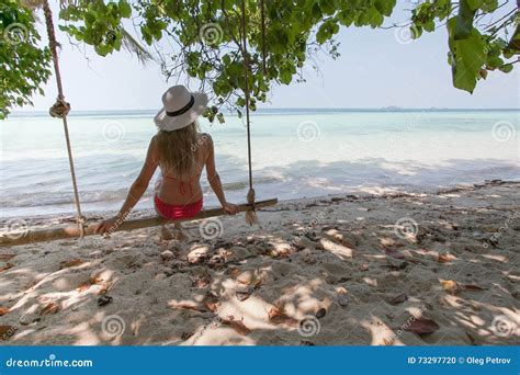Beautiful Young Woman On A Swing Resting On Exotic Beach Wellness