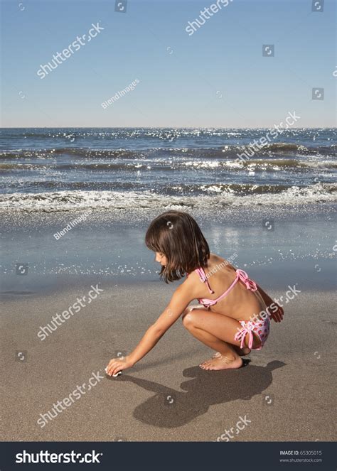 Side View Of Girl Picking Up Shell On Sand At Beach Stock Photo Shutterstock