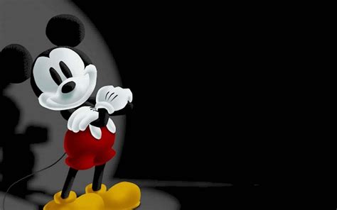 Download Mickey Mouse Standing In Front Of A Dark Background Wallpaper