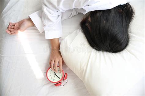 Asian Woman Lazy Sleep Waking Up On Bed With Clock In White Bedroom