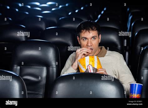 Man Eating Popcorn While Watching Movie In Theater Stock Photo Alamy