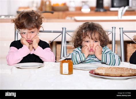 Kids Pouting In The Kitchen Stock Photo Alamy