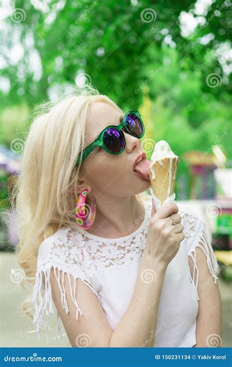 Beautiful Young Blonde Girl With Ice Cream In Her Hands Licks The Ice