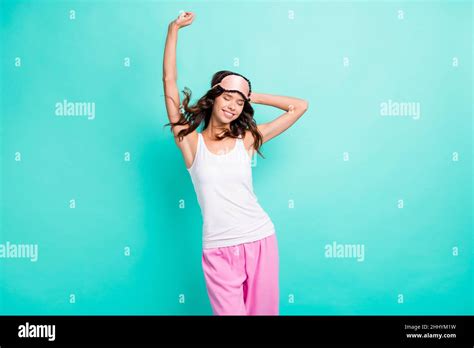 Photo Of Cute Adorable Young Woman Sleepwear Stretching Arm Hand Behind Head Isolated Turquoise