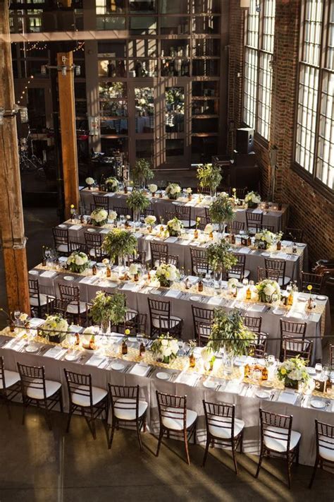 The Tables Are Set With White Linens And Greenery For An Elegant