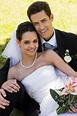 Feliz pareja de recién casados jóvenes sentados en el parque | Foto Premium