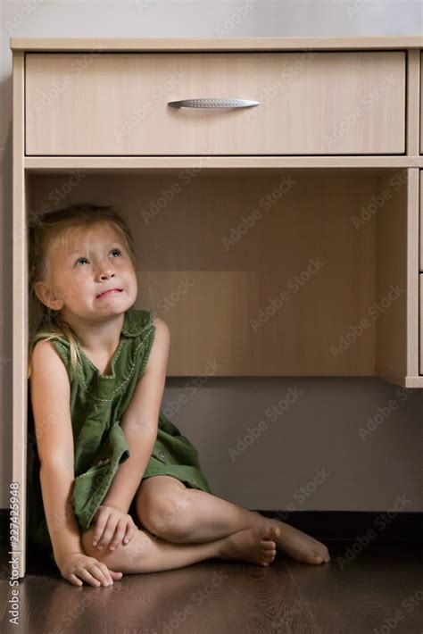 Childhood Fears Scared Little Girl Hiding Under The Table Stock Photo
