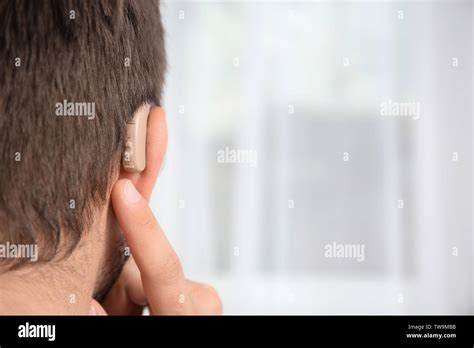 Young Man With Hearing Aid Indoors Stock Photo Alamy