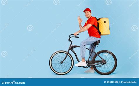 Deliveryman Riding Bike and Gesturing Okay on Blue Background Stock