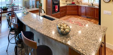 A Large Kitchen With Granite Counter Tops And An Island In Front Of The
