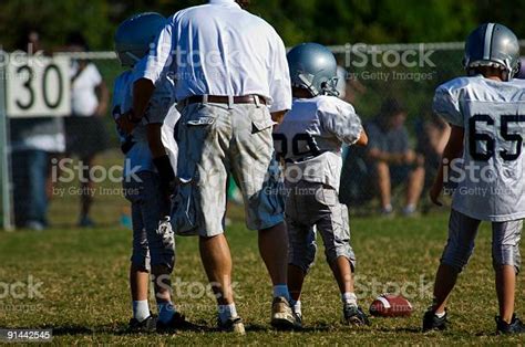 Football Coach Instructing Football Players During A Football Game