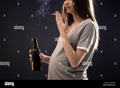 Pregnant Woman Smoking Cigarette And Drinking Beer On Dark Background