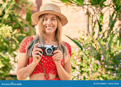 Young Blonde Tourist Woman Wearing Summer Style Using Vintage Camera At