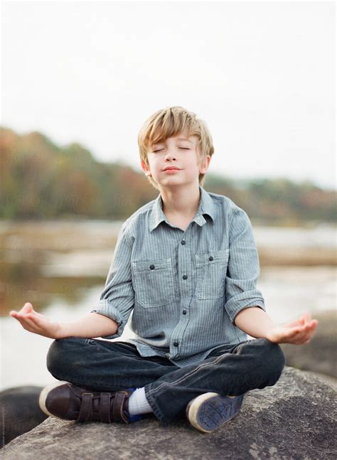 Young Boy Meditating On A River Rock by Marta Locklear