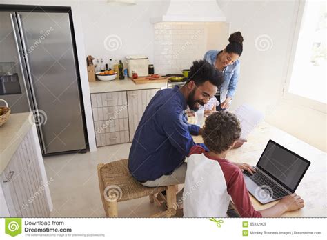 Parents Helping Kids With Homework In Kitchen Elevated View Stock
