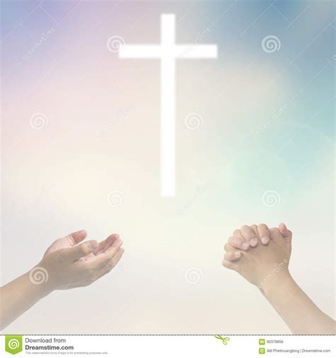 Open Hands Praying The Cross On Blur Sky Background Stock Photo