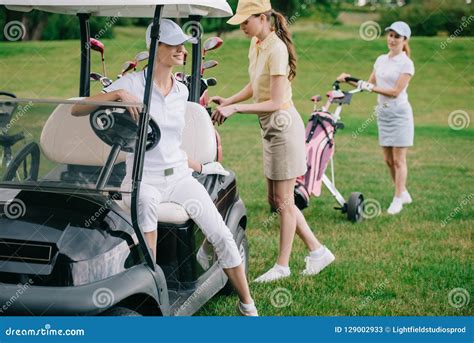 Selective Focus Of Female Golf Players In Caps At Golf Cart Stock Image