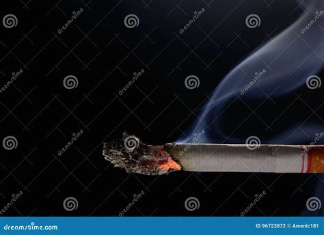Lit And Burning Cigarette With Smoke On Black Stock Photo Image Of