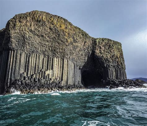 The Rock Formation Is Surrounded By Water And Rocks