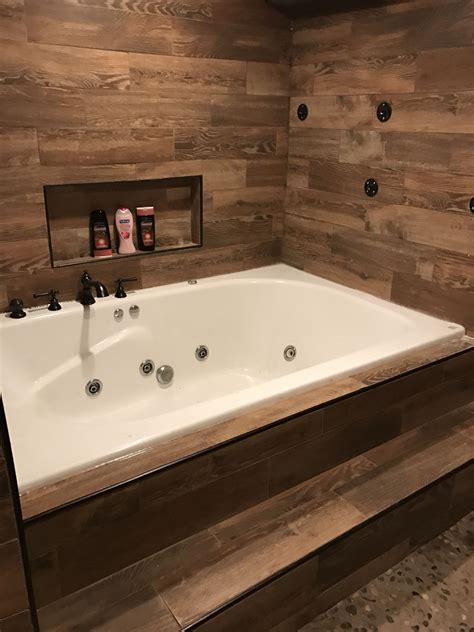 A wooden enclosure provdes warmth and character, and easy access to plumbing. Huge jet tub with large niche. Step to easily get in from ...
