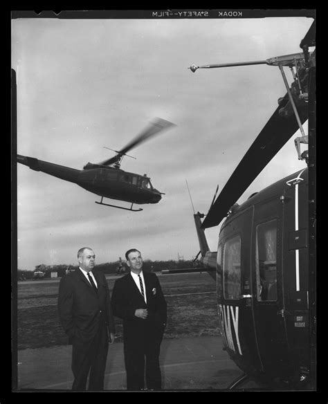 Photograph Of Two Men In Suits Standing By A Uh 1a Iroquois Helicopter