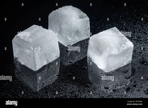Three Ice Cubes On Black Glass Stock Photo Alamy