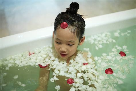 Cute Asian Little Girl Bathing In A Bathtub Full Of Petals By