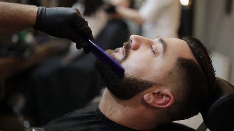 Barber Shaves Beard Of Client With Trimmer Stock Footage Sbv
