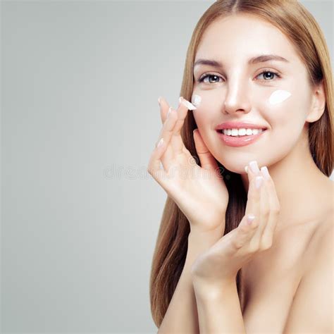 Closeup Portrait Of Cheerful Young Woman With Healthy Skin Applying Day