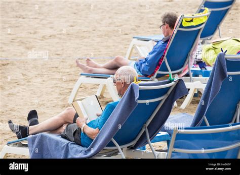 Mature Men Reading Books On Beach In Spain Stock Photo Alamy