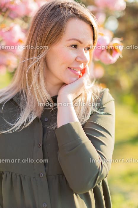 Freckled Blonde Pregnant Woman In The Park At Spring With Sakuraの写真素材 [146801287] イメージマート