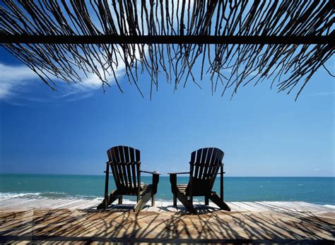 Your adirondack beach chairs stock images are ready. Two Chairs On Deck By Ocean Shaded By Grass Roof ...