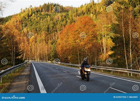 Asphalt Road In The Autumn Landscape With A Ride Motorcycle Over The