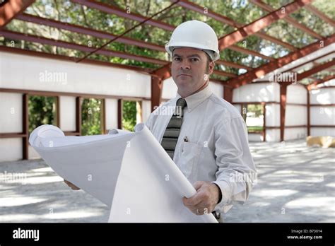A Construction Engineer Reviewing Blueprints On The Jobsite Stock Photo