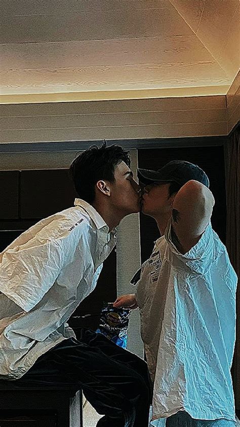 Two People Kissing Each Other In Front Of A Mirror