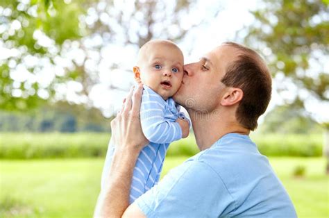 Portrait Of Young Father Kissing His Newborn Son Stock Photo Image Of
