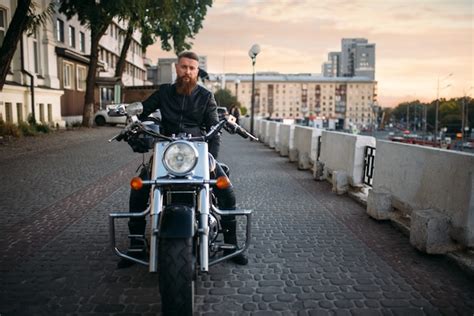 Premium Photo Bearded Biker In Leather Jacket Poses On Chopper In City