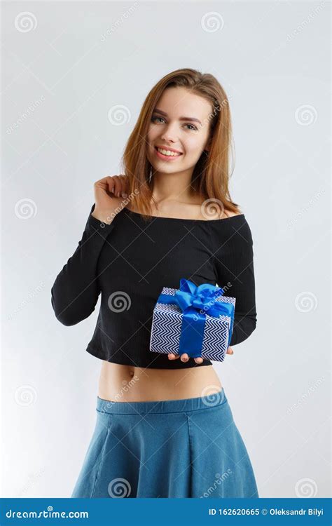 Молодая красивая девушка с подарком в руках Стоковое Изображение изображение насчитывающей