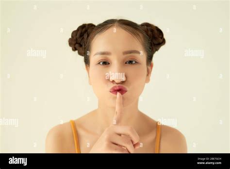 Keep In Secret Portrait Of Playful Positive Asian Teen Girl With Buns Hairstyle Showing Silence